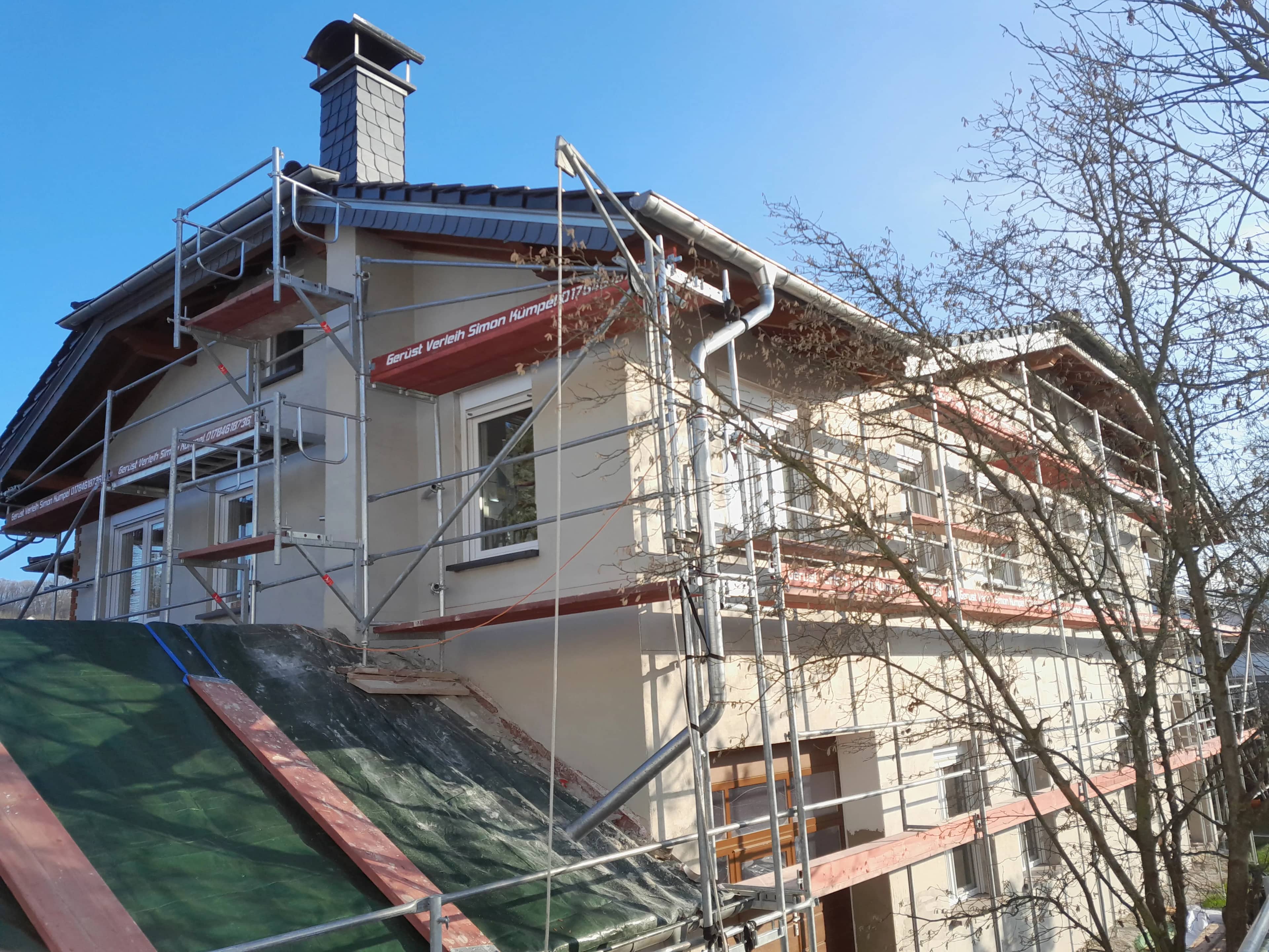 Fassadengerüst am Giebel eines Einfamilienhauses mit Schieferschornstein